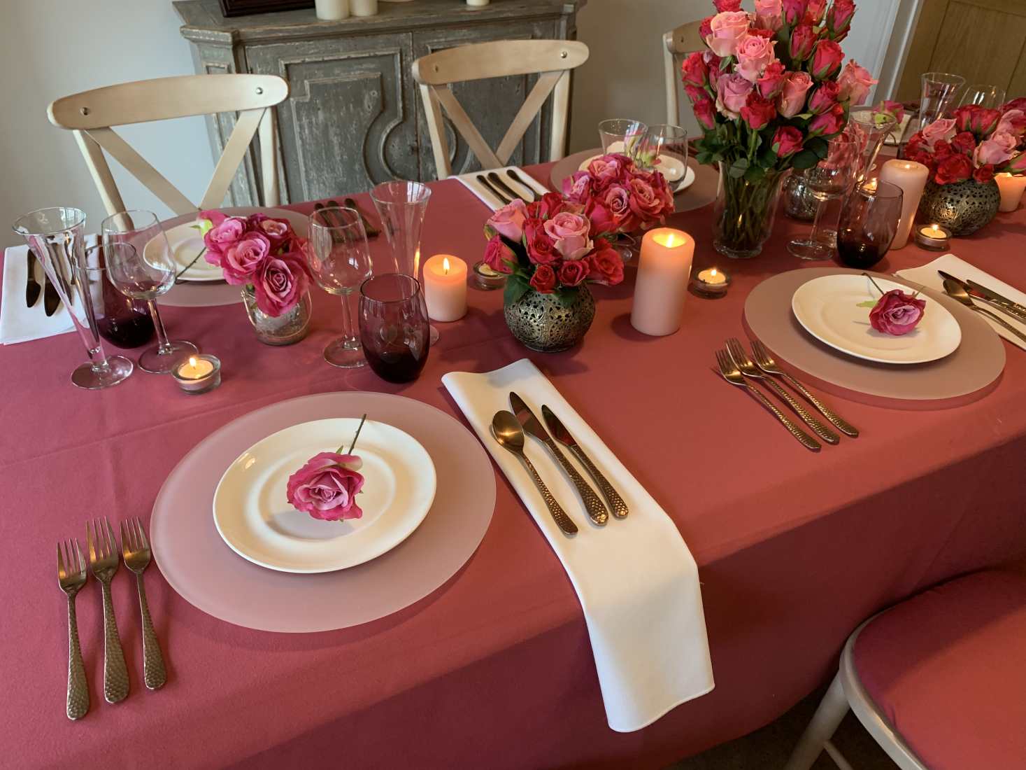 A beautifully laid wedding table with chairs, table linen, flowers and glasses in Viva Magenta wedding colour trend with white and other accents.